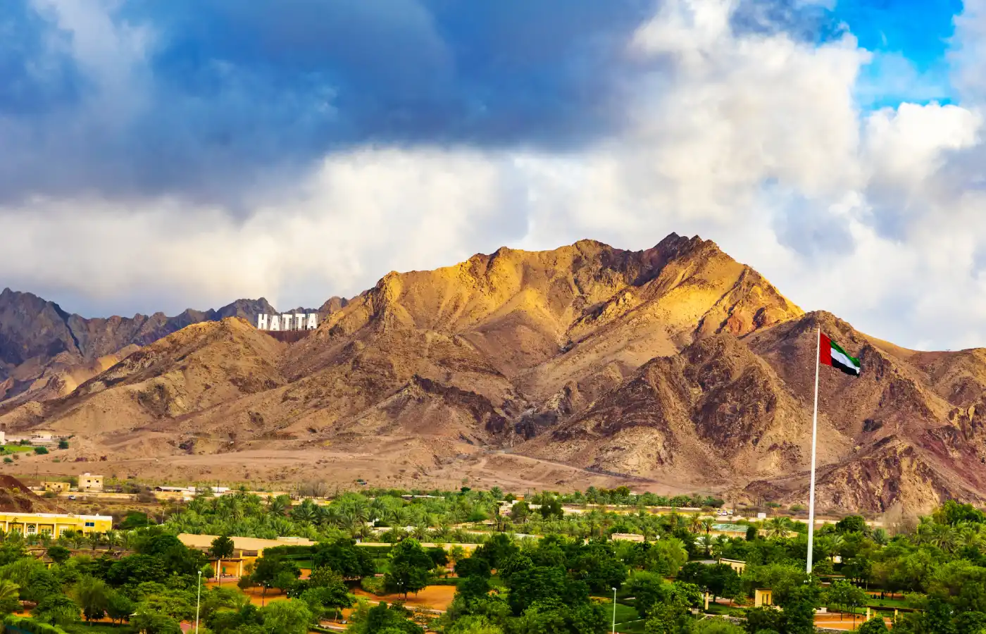 Hajar mountains and UAE flag flying high in Hatta enclave of Dubai