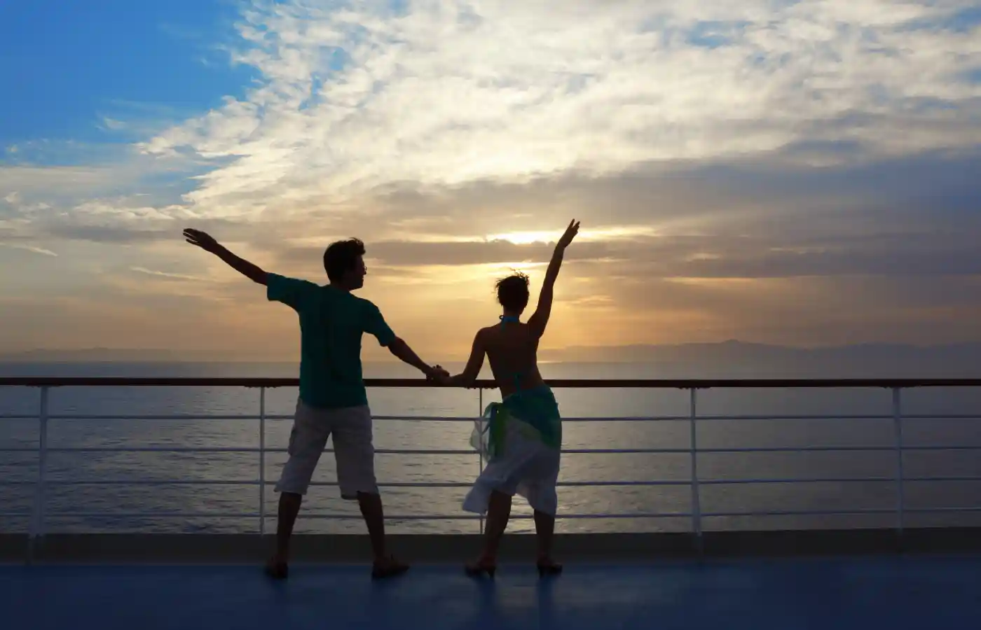 man and woman standing on deck of cruise ship and looking away