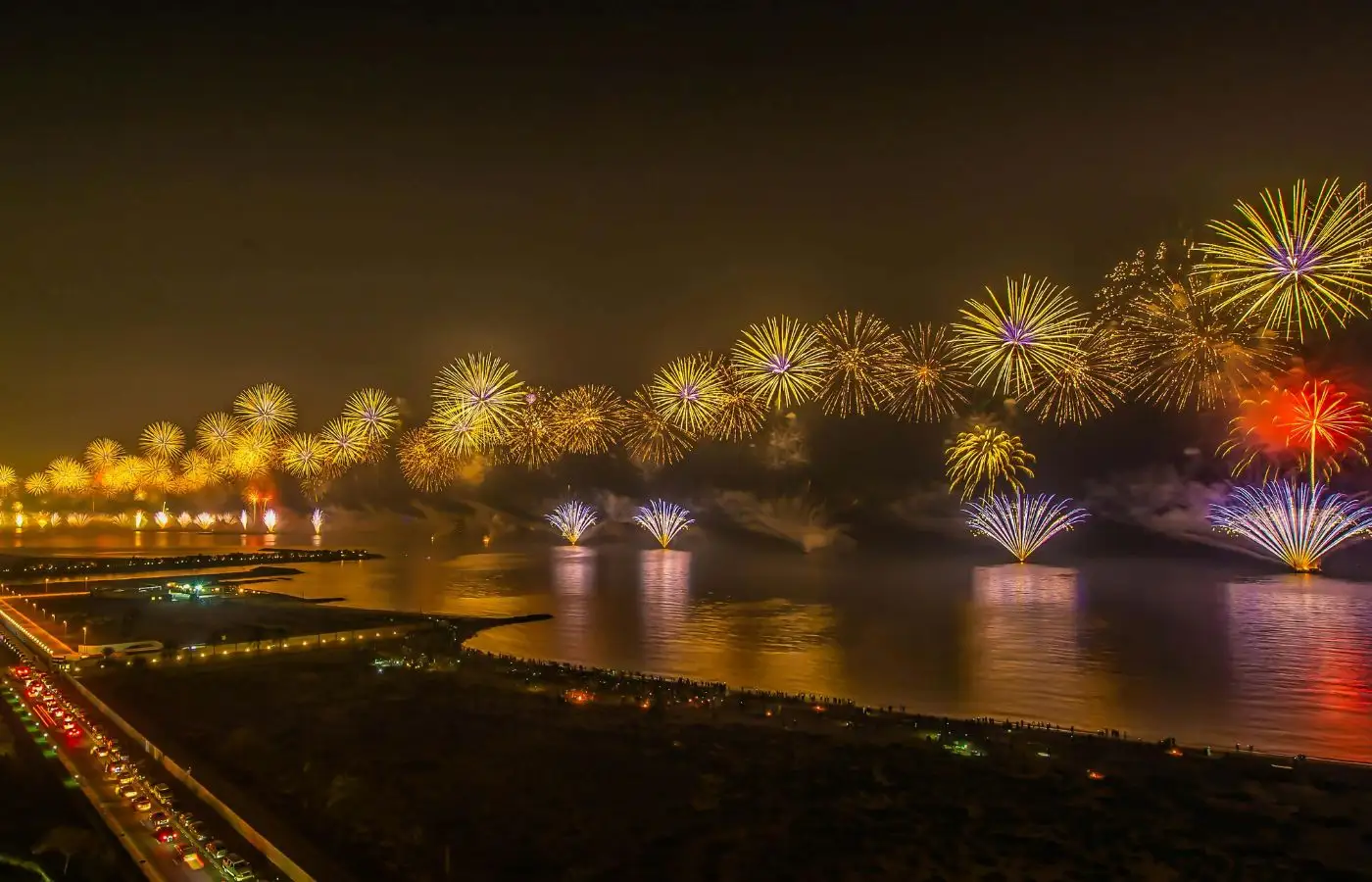 Burst of Fireworks Over a Body of Water Near a City