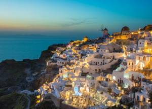 sunset view of houses on mountains near sea at Oia in Greece.