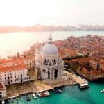 Buildings near clear body of water in Venice , Italy.