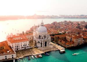 Buildings near clear body of water in Venice , Italy.