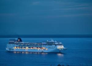 White color cruise ship in water with lightings.