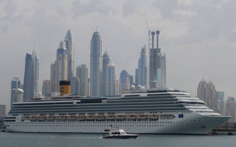 Cruise ship in Dubai city with skyscrapers.