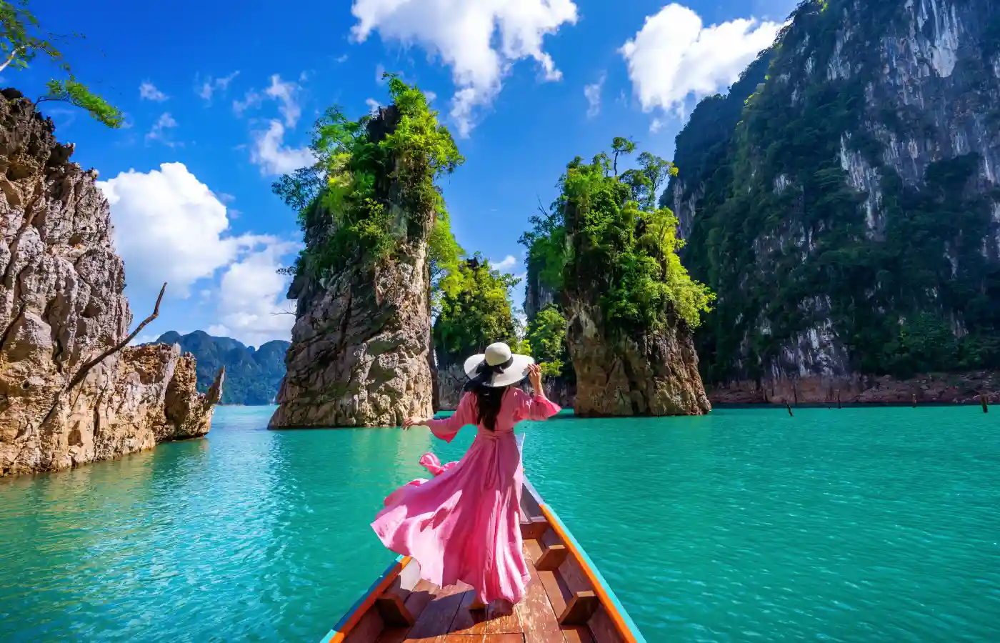 Beautiful girl standing on the boat and looking to mountains