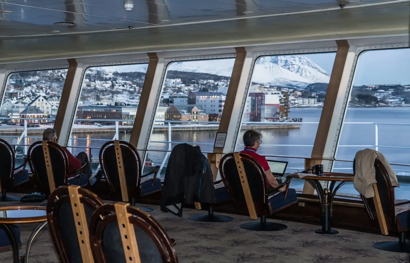 A man sitting in a cruise with laptop.