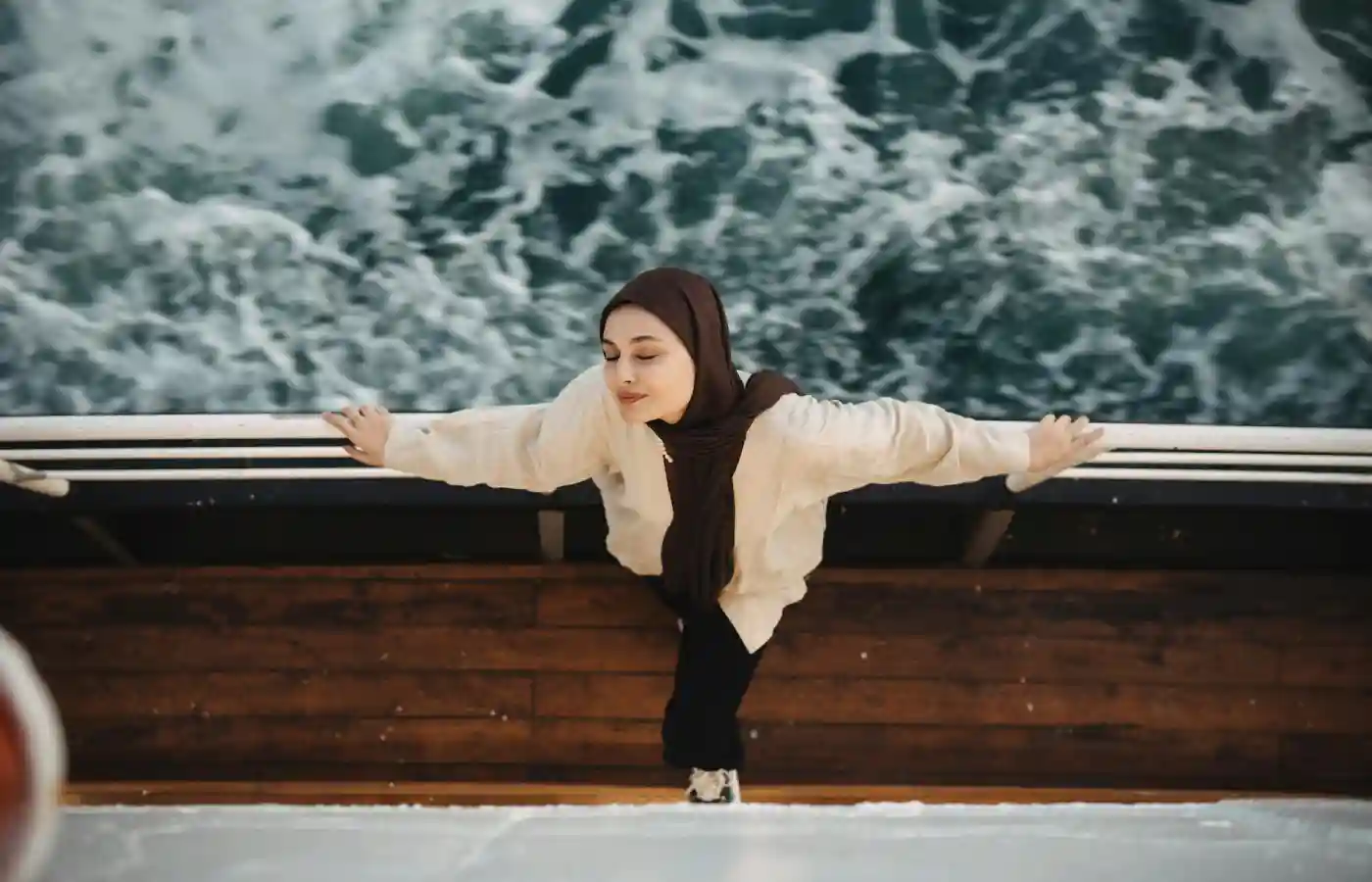 Woman leaning against the taffrail on a cruise.