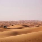 Person riding an atv on a desert.