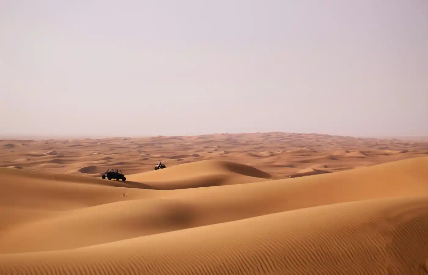 Person riding an atv on a desert.