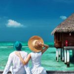 Couple on a tropical beach jetty at Maldives