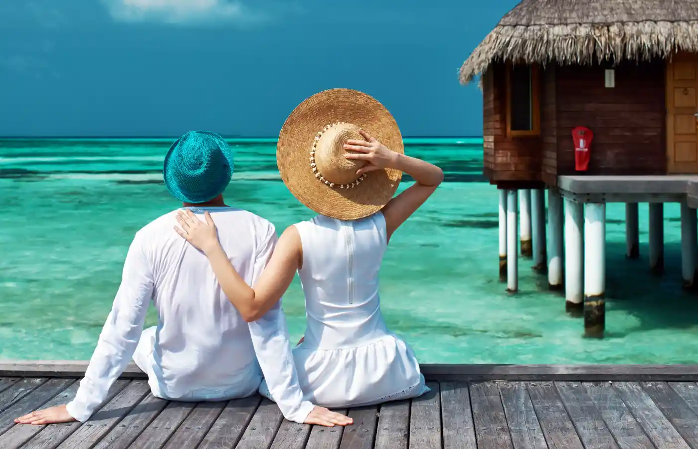 Couple on a tropical beach jetty at Maldives