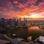 Photo of Singapore city under orange sky.