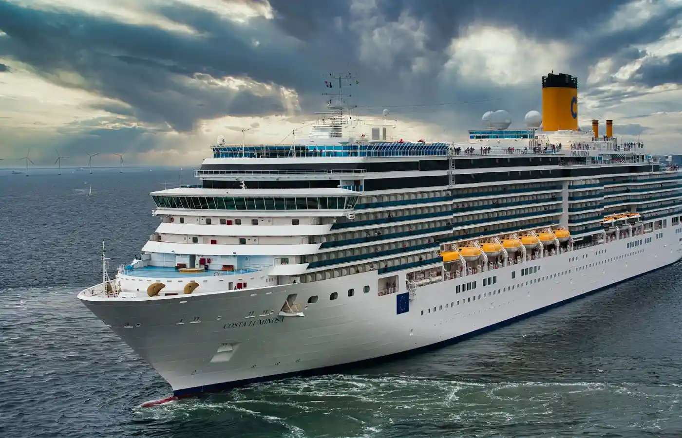 White cruise ship on sea under white clouds and blue sky during daytime