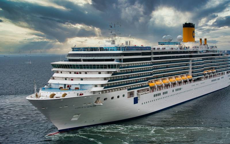 White cruise ship on sea under white clouds and blue sky during daytime