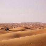 Brown sand in vast desert during the day time in Dubai.