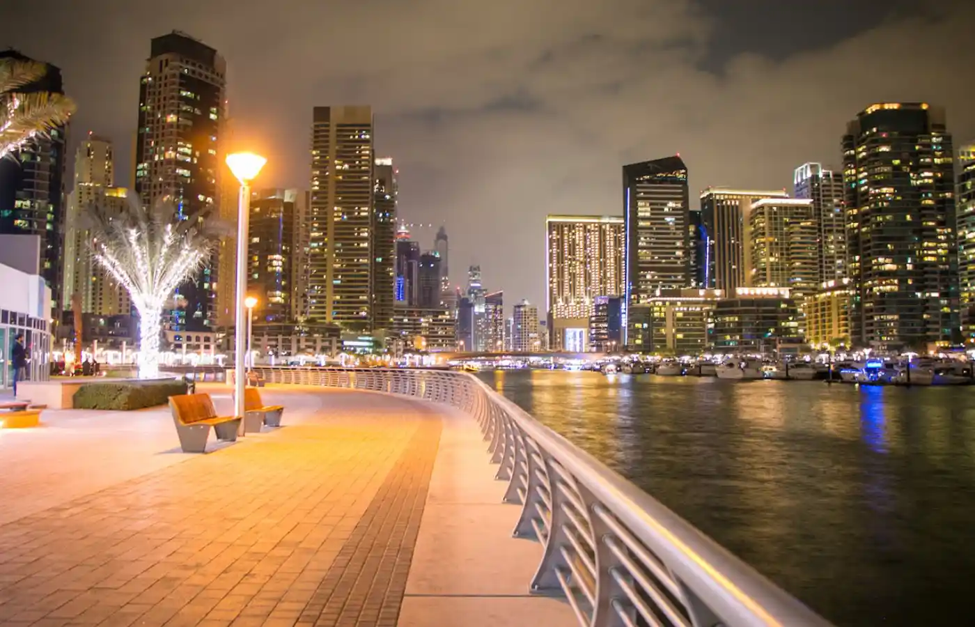 City buildings with lights near a body of water.
