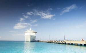 A white color cruise ship at a port.