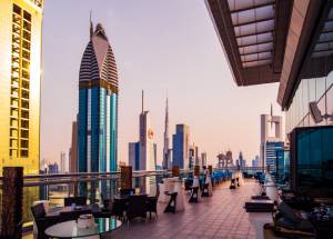 skyscrapers of downtown Dubai from a rooftop coffee bar at sunset