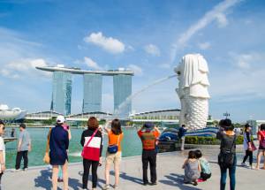 Tourist taking pictures at Merlion in Singapore.