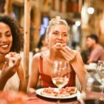 Woman eating bruschetta at a restaurant.