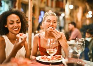 Woman eating bruschetta at a restaurant.