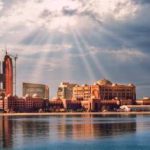 Huge buildings near water under the sky in Abu Dhabi.