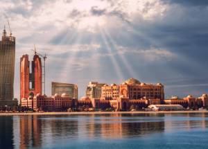 Huge buildings near water under the sky in Abu Dhabi.