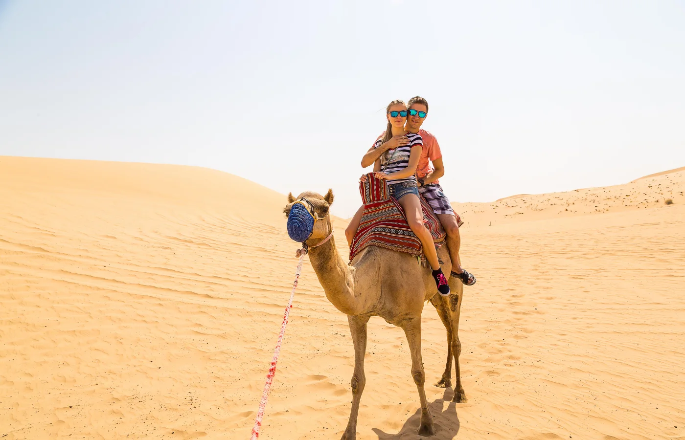 Couple riding camel in Abu Dhabi desert