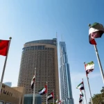 UAE flags waving besides Dubai Mall and Burj Khalifa.