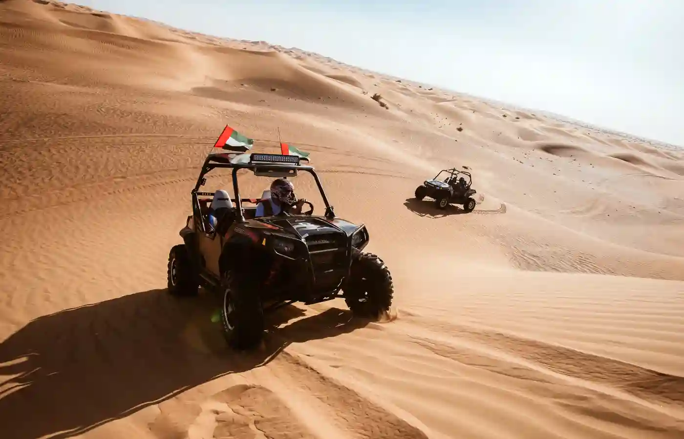 Man riding a dune buggy in desert.