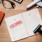 visa and passport with denied stamp on a document top view in immigration.
