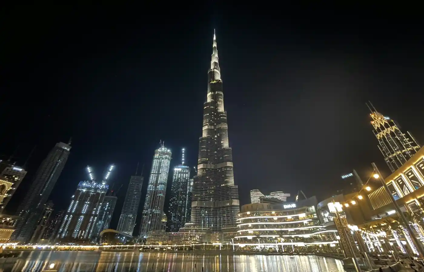 Tall building towering over a city at night in Dubai.