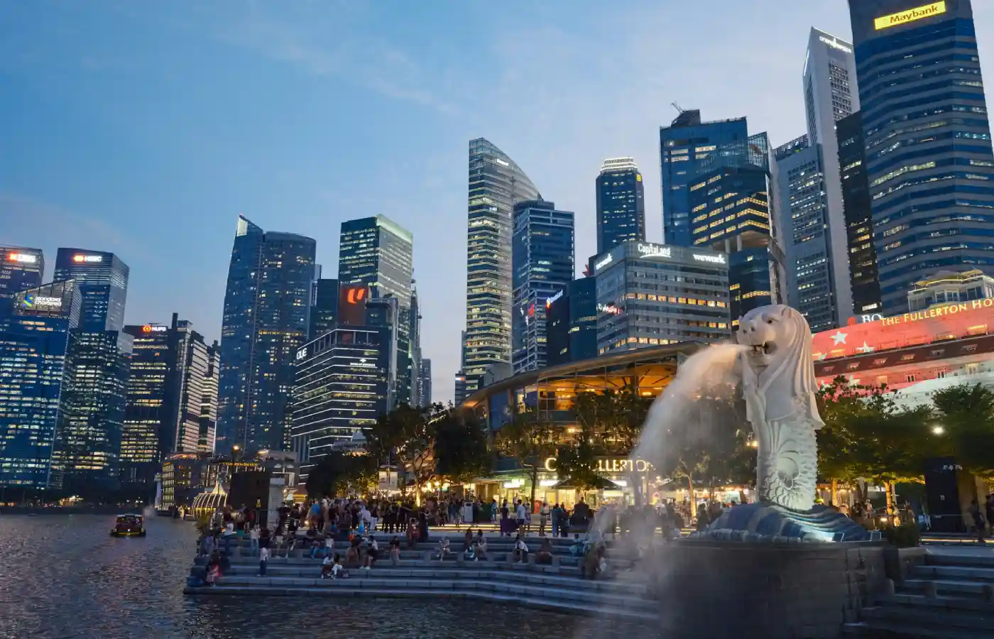 A city skyline with a fountain in the foreground.