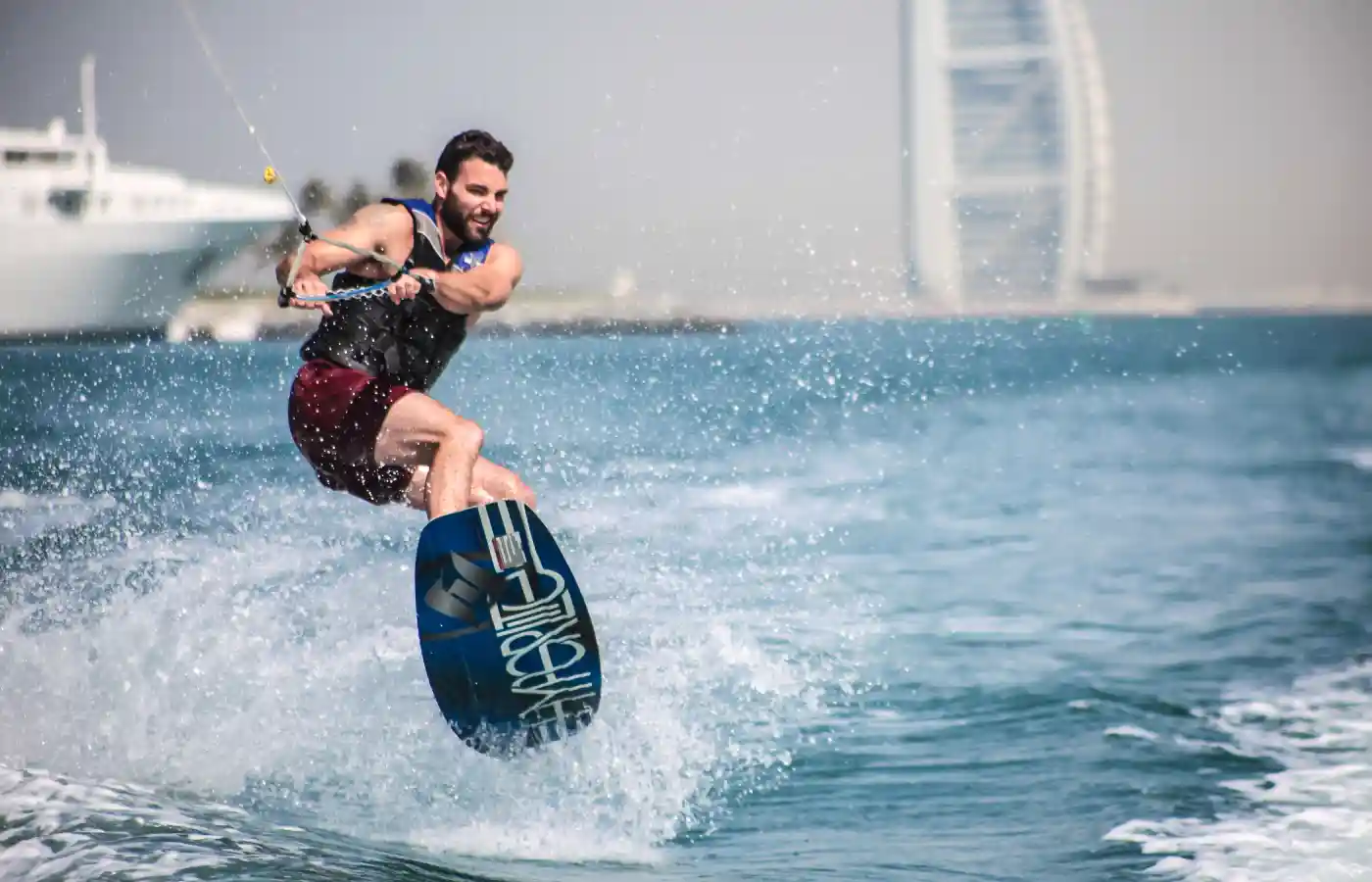 Wakeboarder enjoying a perfect day in Dubai Marina with Burj Al Arab in the background