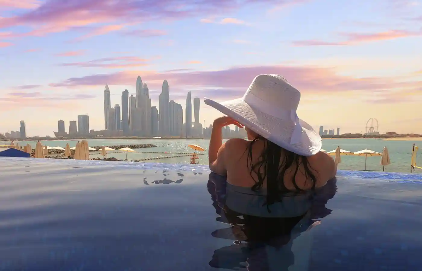 Woman with a white hat at Dubai Marina at the sunset