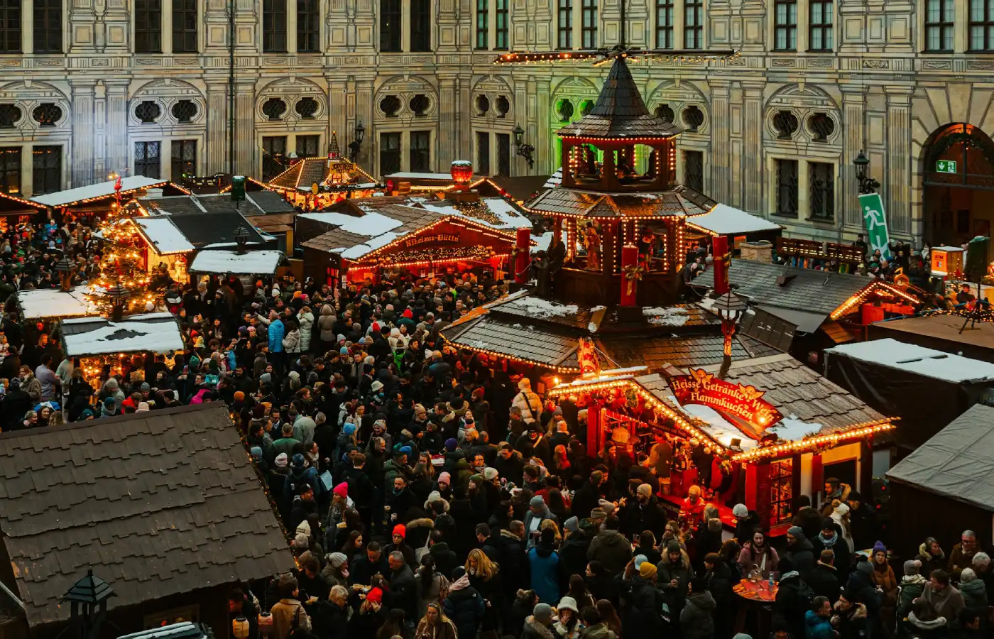 Crowd of people standing around a christmas market in Germany.