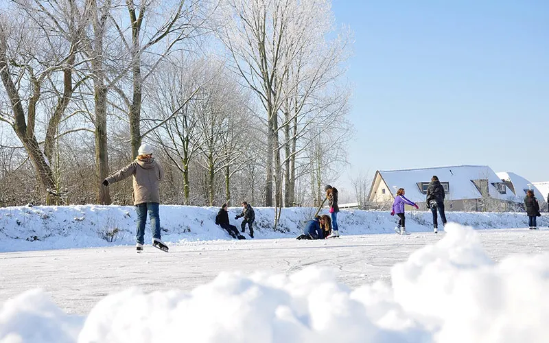 Snow-covered Netherlands with ice skaters