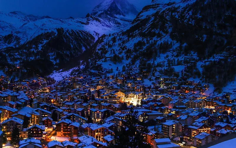 Swiss mountain village with illuminated townhouses at night