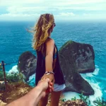 couple holding hand on island with sea view