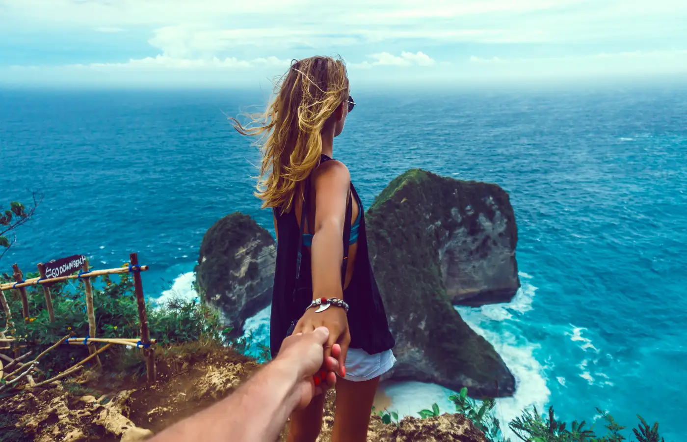 couple holding hand on island with sea view