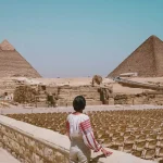 Woman standing and looking at the pyramids