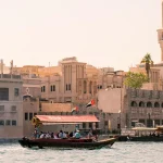 a boat passing through the architecture of old dubai