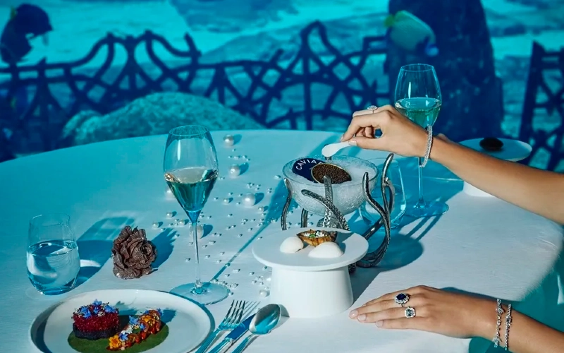 Food served on a table at Ossiano, in Hotel Atlantis, with fish swimming in the background