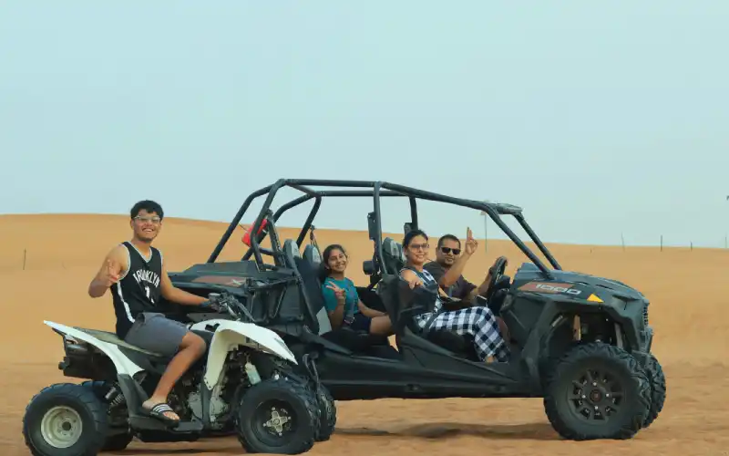 Family Riding Quad and Buggy on Desert