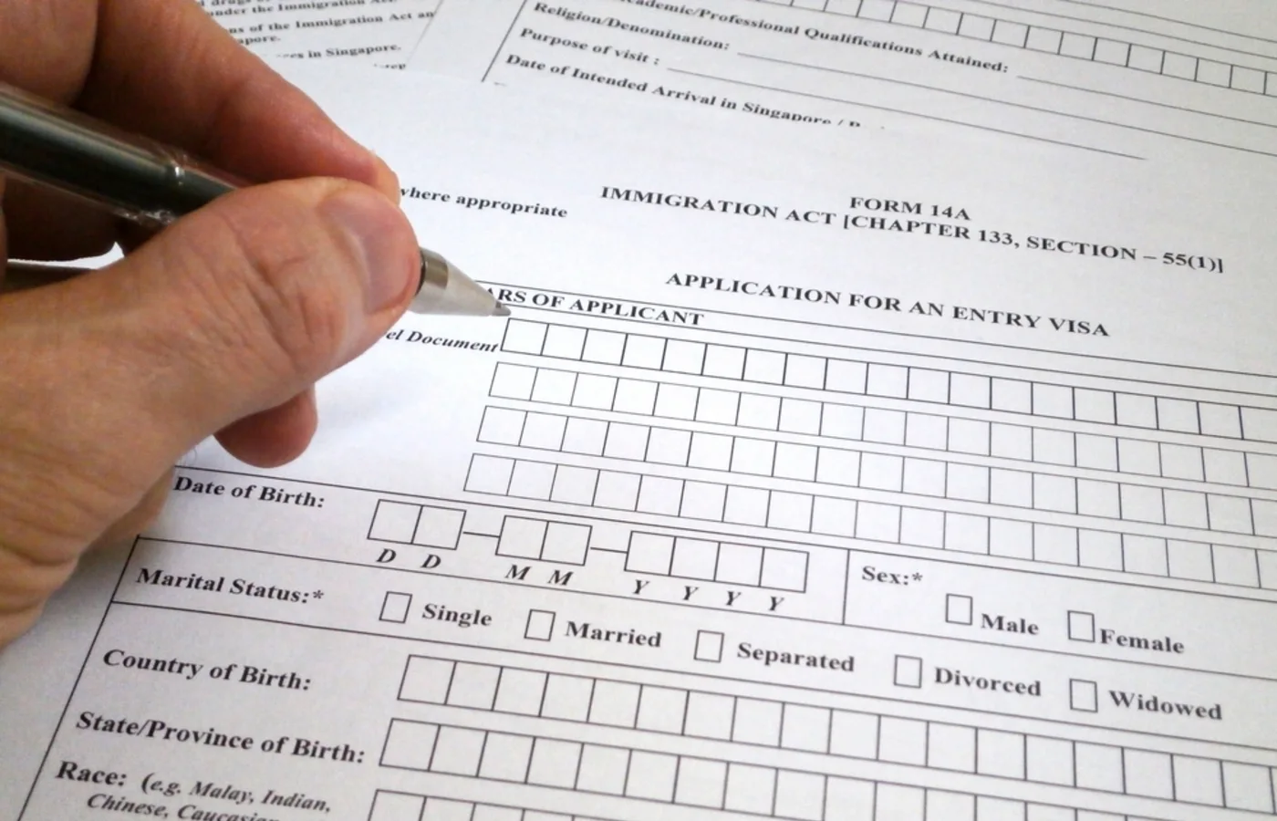 Someone filling form 14A Singapore visa
