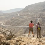 two hikers are admiring the view of mountains near Dubai