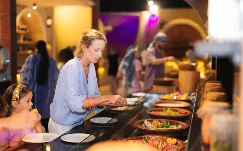 People taking food to eat at desert safari camp in Dubai.