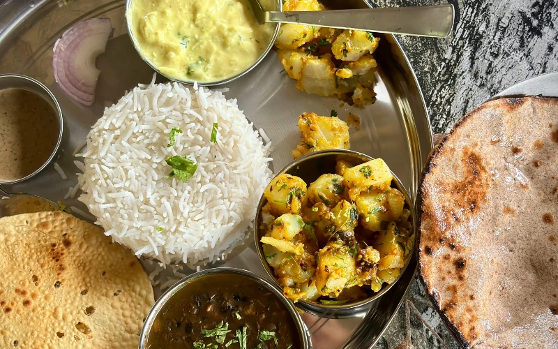 a vegetarian Indian spread served in a typical plate called thali
