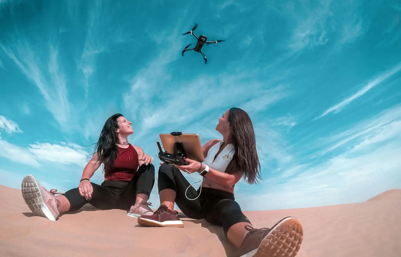 Two Women in the Dubai desert operating a drone